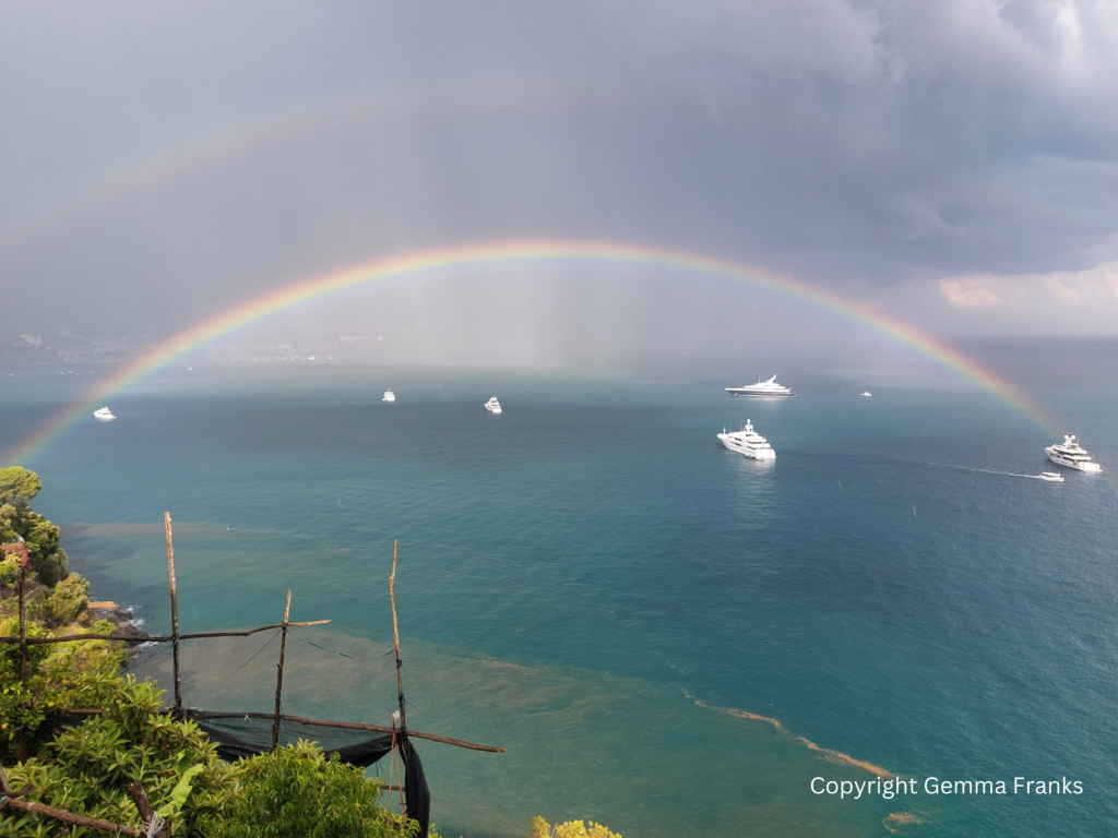 Double rainbow above boats in the sea